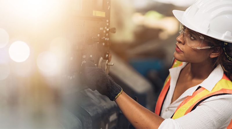Image of a women in a hard hat and high visibility wear operating manufacturing machinery to support women in manufacturing article