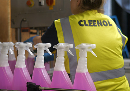 plastic bottles of pink cleaning fluid on production line