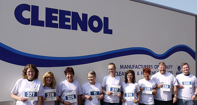Cleenol Group staff standing in front of company sign holding numbers