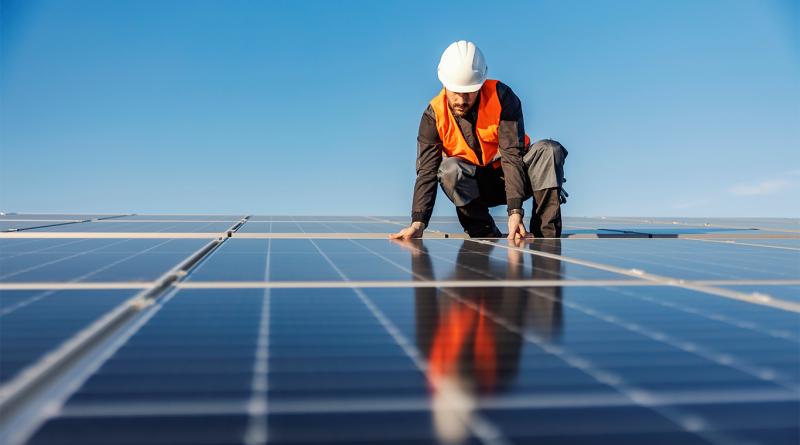 Image of a construction worker fitting solar panels to support solar manufacturing article