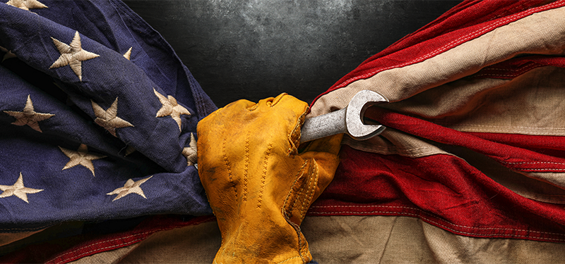 American Flag being held by a hand with working gloves on to support Made in USA Day article