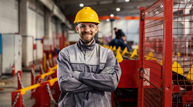 Manufacturing worker smiling at camera in warehouse to support article