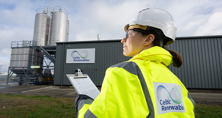 Celtic Renewables employee in high visibility juacket & white hard hat outside Grangemouth facility