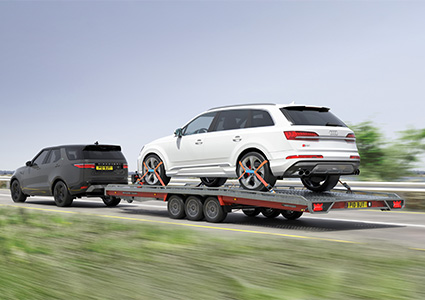 Flatbed trailer carrying white Audi Q7