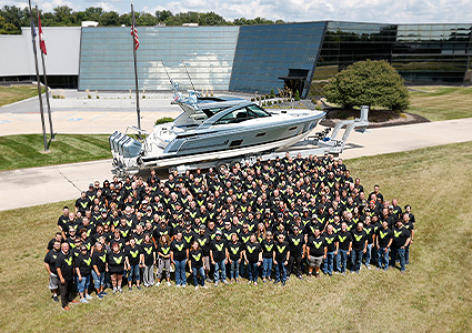 Formula Boats staff outside their office standing infront of a powerboat