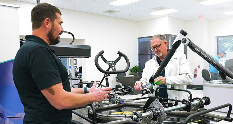 Technicians taking precise measurements on Kart frame