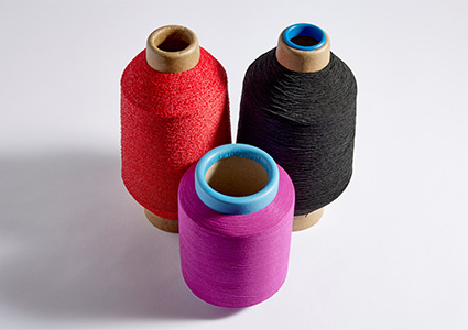 Three bobbins of coloured yarn