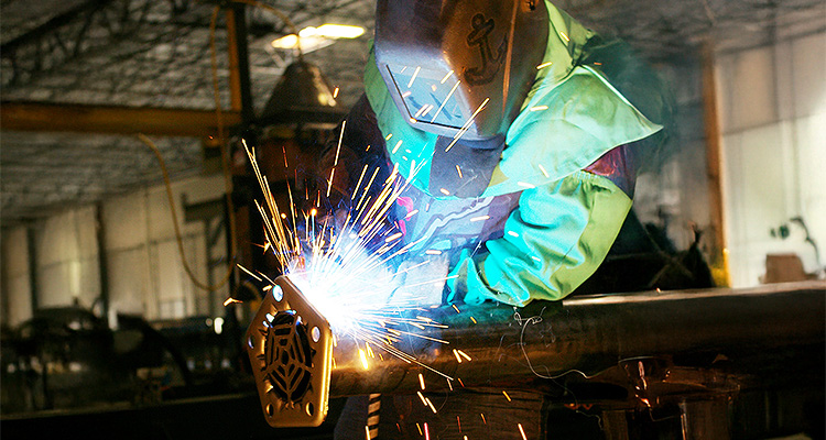 Welder welding on a metal tube