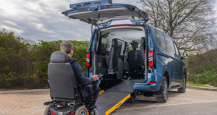 Wheelchair going up a ramp into a modified minibus