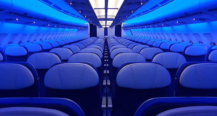 the interior cabin of an Air Transat aircraft, featuring their distinctive blue mood lighting