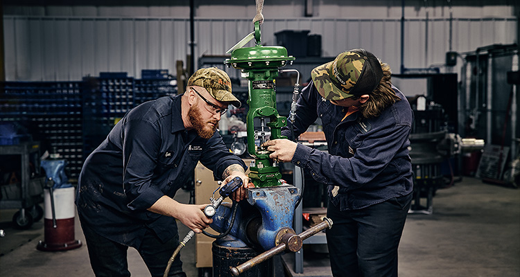 technicians working on an industrial control valve