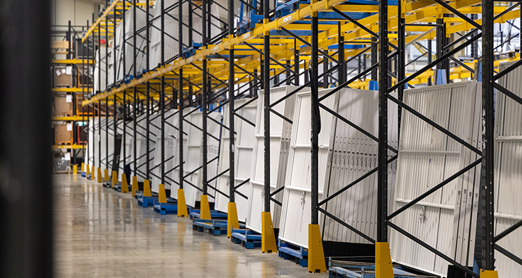 From pioneering design to cutting-edge automation, Garador blends British manufacturing with German engineering Warehouse with rows of white garage doors