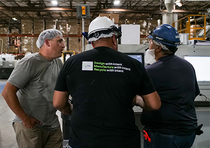  three individuals working in a warehouse or manufacturing setting