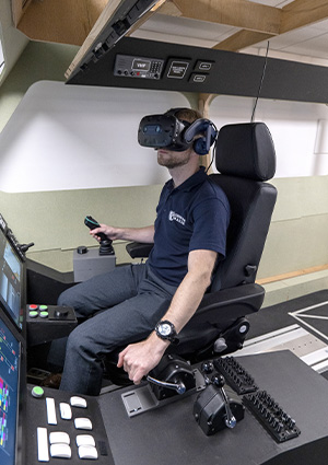 a man in a simulator setup, utilizing virtual reality technology for training purposes