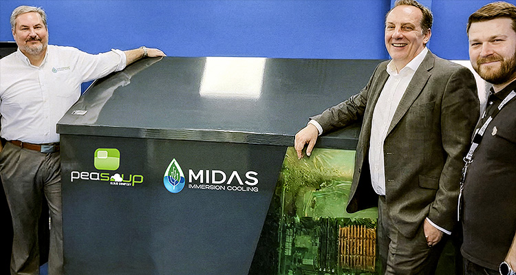 three men standing next to a black immersion cooling unit