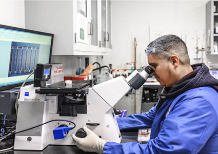 a person using a high-powered laboratory microscope