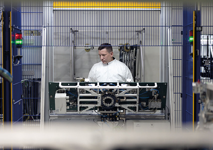 a person in a white lab coat is working on a complex piece of machinery.