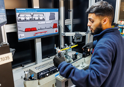 a person working with industrial machinery and a computer monitor