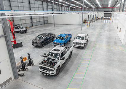 five large pickup trucks in a warehouse