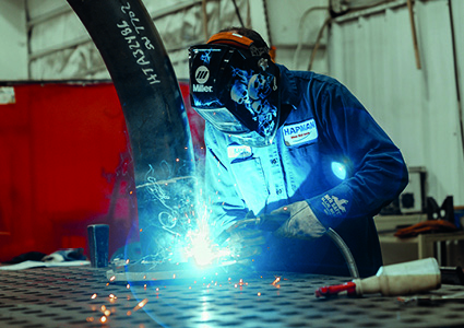 a professional welder performing fabrication work on a metal structure