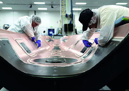 technicians working on a large composite or industrial component