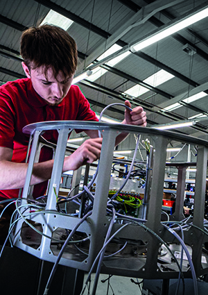 an employee at PP Control & Automation wiring a complex machine frame