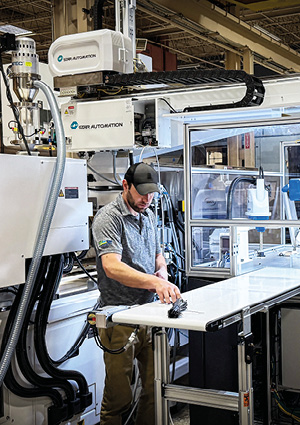 a male manufacturing employee working alongside a collaborative robot