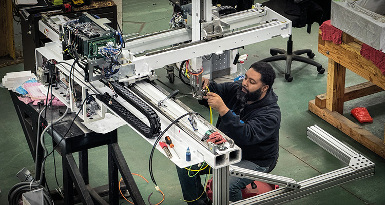 a technician or engineer performing maintenance or assembly on a complex industrial automation system
