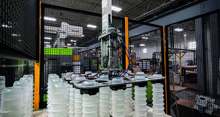 The image shows a robotic arm engaged in industrial packaging