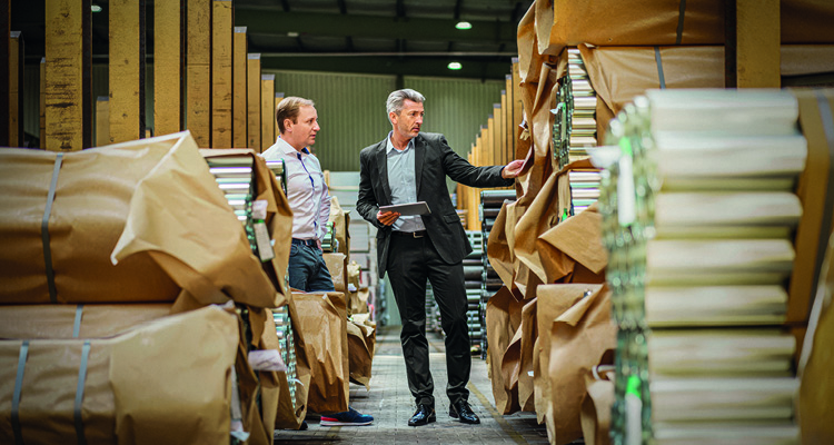 business professionals conducting an inventory check inside a warehouse