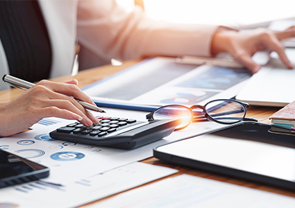 a person working on financial documents using a calculator