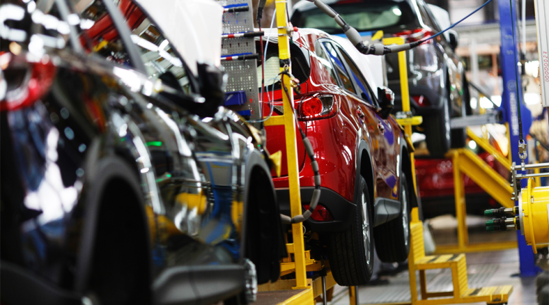 A red crossover is standing on a transport tape at a car factory