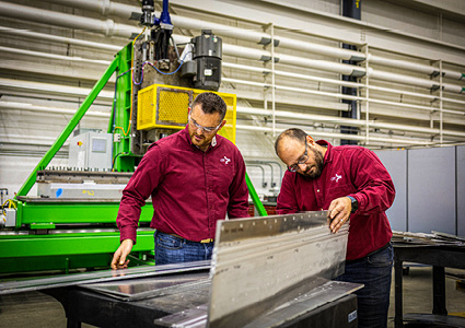 two technicians inspecting a component created using advanced friction stir welding (FSW) technology at a Concurrent Technologies Corporation (CTC) advanced manufacturing facility