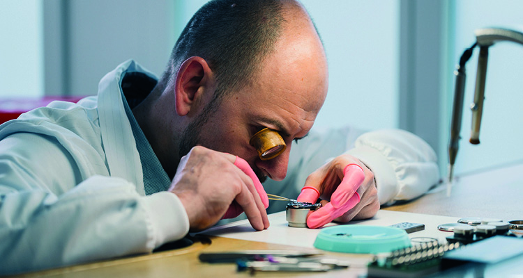 a watchmaker utilizing tools to repair a watch movement