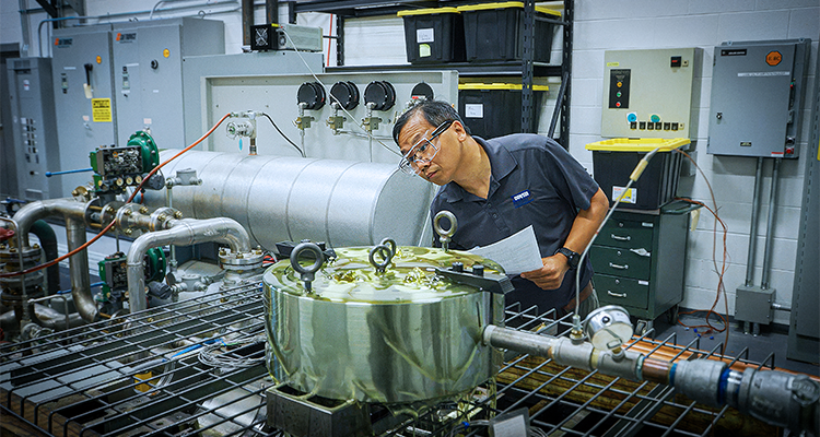 a person inspecting industrial machinery in a laboratory or manufacturing setting