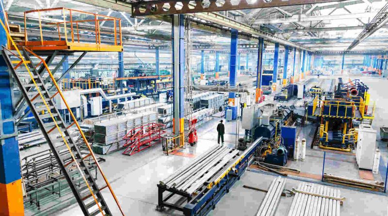 US manufacturing workers operating advanced machinery in a modern factory as production increases while employment declines.