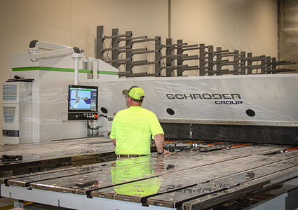 a worker operating a Schroder Group industrial metal folding machine 