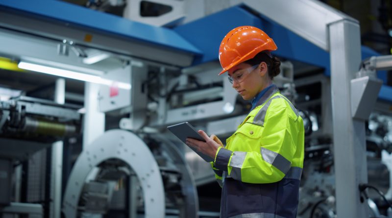 Manufacturing worker oversees automated production equipment inside a modern Texas factory as industrial output increases amid rising operating costs.