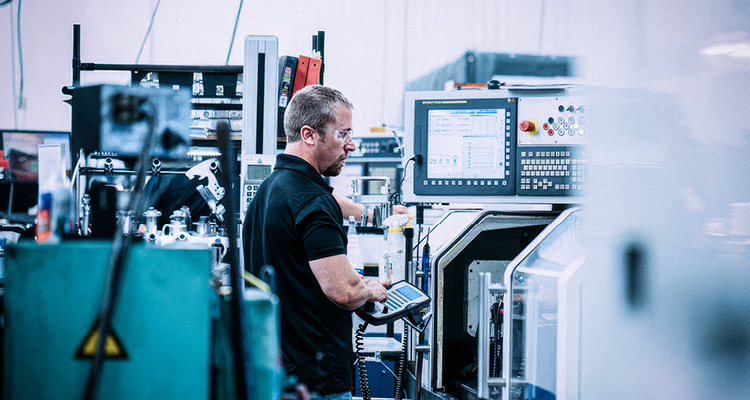 an industrial manufacturing environment with a technician operating complex machinery.