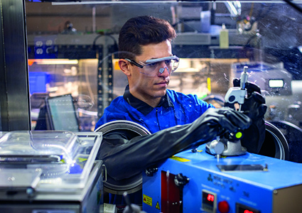 a  technician works inside a laboratory cleanroom environment using a specialized isolation enclosure