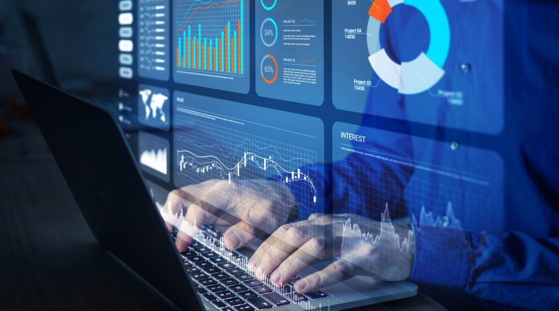 Worker at key board with data analysis on screen
