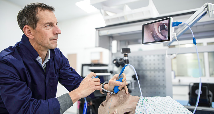 a clinical simulation setting where a medical instructor or clinician is demonstrating a specialized airway management procedure