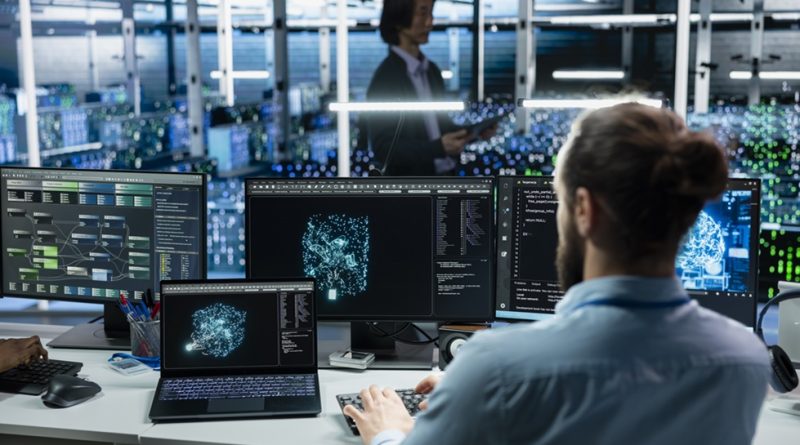 worker studying screens with manufacturing data