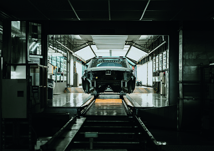 an automotive manufacturing facility with a vehicle body shell moving along a automated conveyor line.