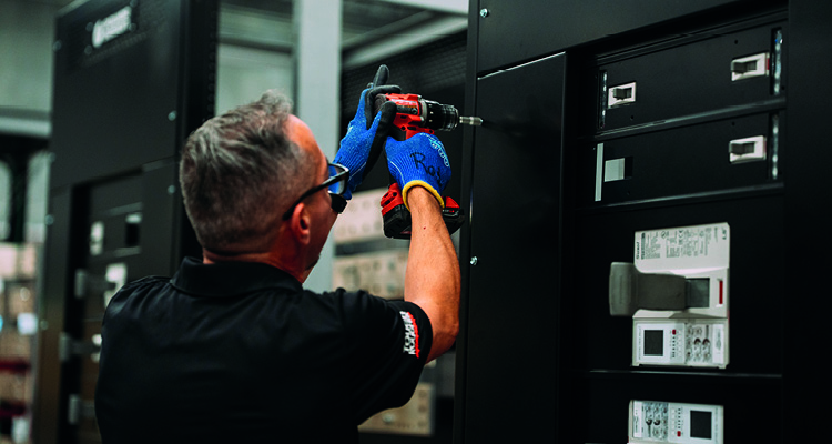 a technician or electrical worker assembling or servicing an industrial electrical control panel or switchgear cabinet