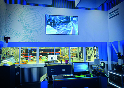 a high-tech control room or demonstration area overlooking an industrial manufacturing floor
