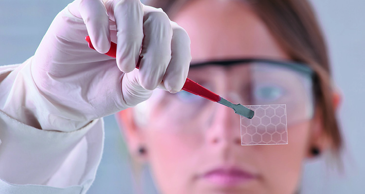 a researcher holding a thin sheet of graphene, a one-atom-thick layer of carbon atoms arranged in a hexagonal lattice