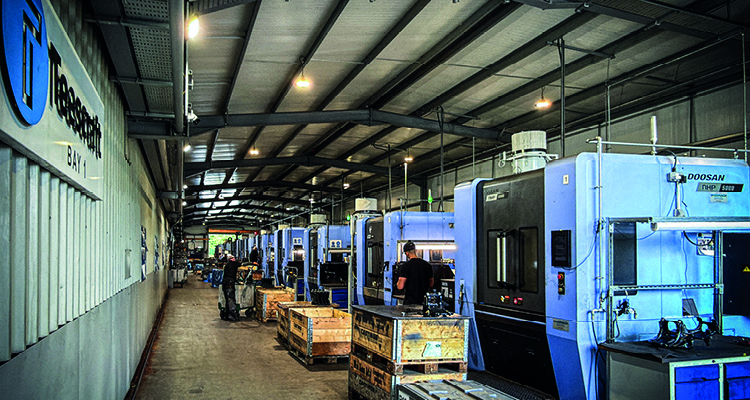 a long row of blue Doosan DNM series vertical machining centers used for precision manufacturing