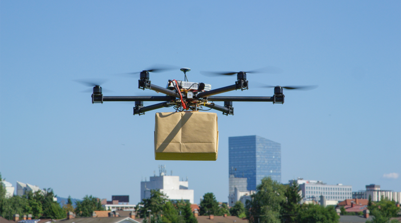 UAV drone delivery delivering big brown post package into urban city