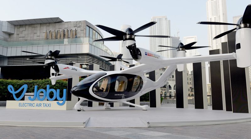 A Joby Aviation electric air taxi during flight, representing the company's manufacturing partnership with Toyota to scale commercial aircraft production.